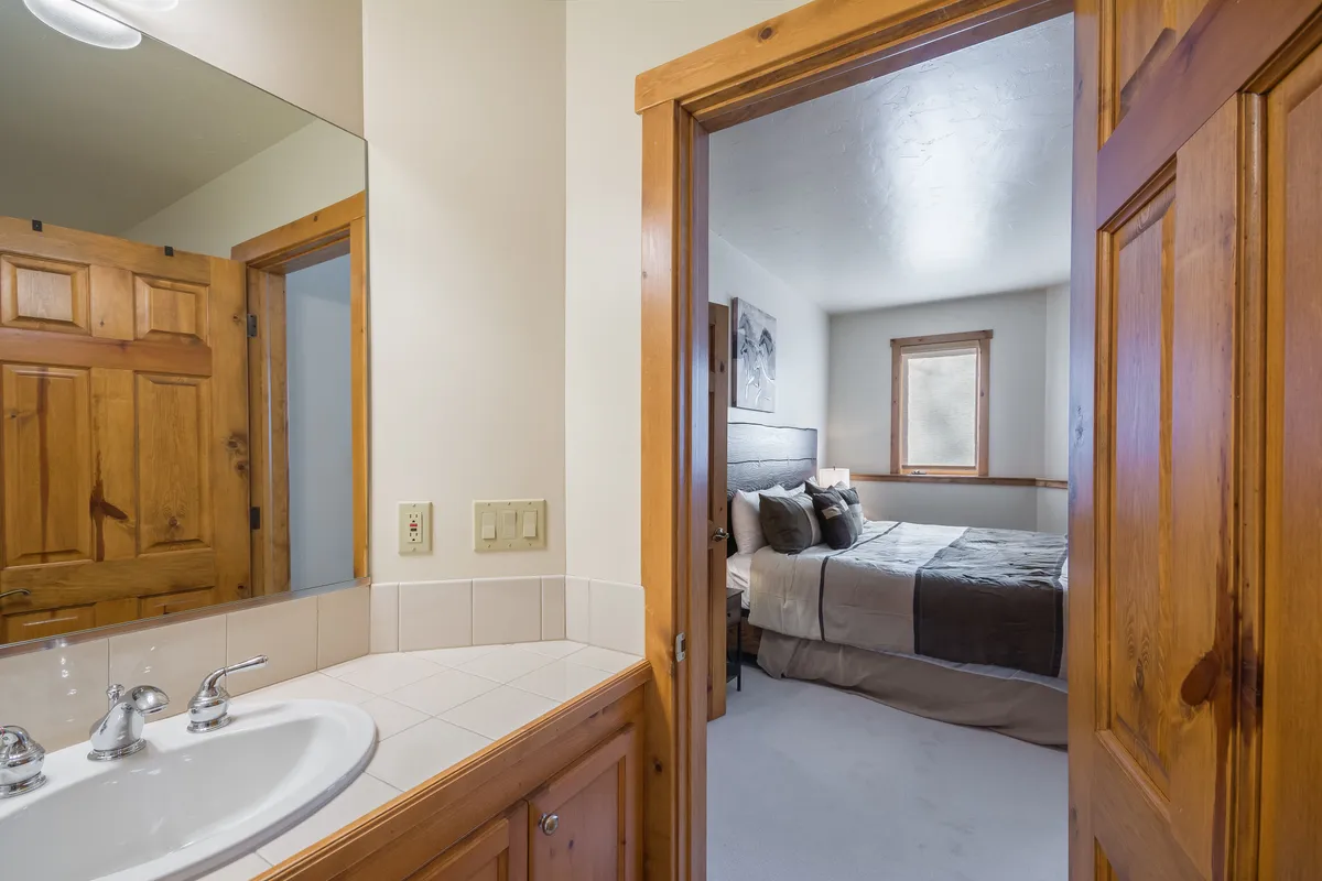 An inviting full laundry room with a vanity, sink, and adjacent view of a bedroom. The space is bright, cozy, and well-organized, making it easy to keep gear fresh after outdoor adventures.